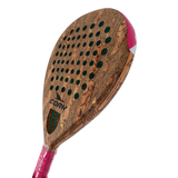 A close-up of a cork paddle racket head with a natural cork texture, green sound holes, a pink and white wrapped handle, and the brand name CORK visible on the face.