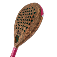 A close-up of a cork paddle racket head with a natural cork texture, green sound holes, a pink and white wrapped handle, and the brand name CORK visible on the face.
