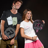 Two people holding padel sports rackets against a black background
